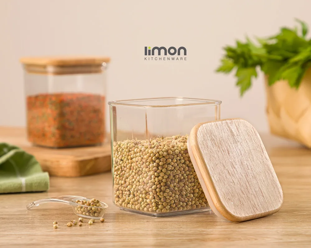 بانکه ادویه چهارگوش شفاف سارینا لیمون با در چوبی و پیمانه پلاستیکی روی میز آشپزخانه