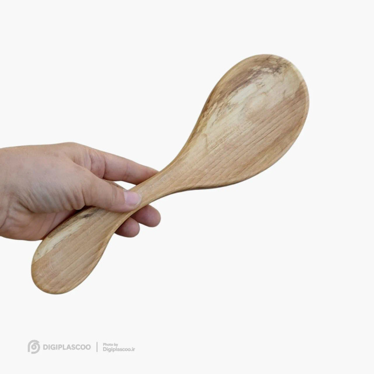 زیر قاشقی چوب گردو نیموود در دست انسان برای نمایش ابعاد و شکل منحنی محصول